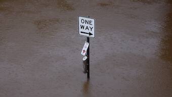 A traffic sign stands submerged in floodwater at the edge of the Wilsons River near Lismore's CBD on March 9, 2025. AFP