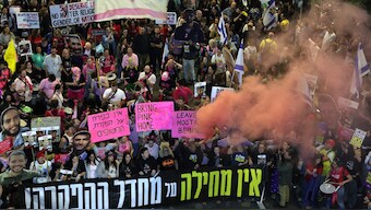 Demonstrators raise placards and and light flares during a protest calling for action to release the remaining hostages held captive in Gaza since the 2023 October 7 attacks by Palestinian militants, outside the Israeli Defence Ministry headquarters in Tel Aviv. AFP