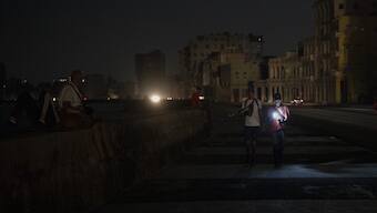 Residents walk on a street during a general blackout in Havana, Cuba. AP
