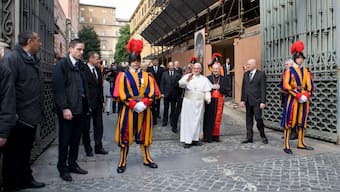 Pope Francis, center left, waves to faithful by making an impromptu appearance to the public from a side gate of the Vatican, startling passersby and prompting cheers, at the Vatican. File image/ AP