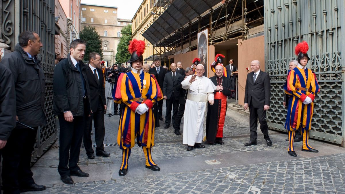 Pope Francis, center left, waves to faithful by making an impromptu appearance to the public from a side gate of the Vatican, startling passersby and prompting cheers, at the Vatican. File image/ AP Pope Francis, center left, waves to faithful by making an impromptu appearance to the public from a side gate of the Vatican, startling passersby and prompting cheers, at the Vatican. File image/ AP