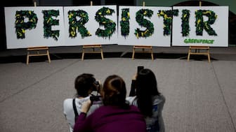 Women take images of installation of placards by Greenpeace with the word “Persist” written on it as the message to the next year’s COP30 in Brazil during the COP29 United Nations climate change conference, in Baku, Azerbaijan November 22, 2024. File Image/Reuters