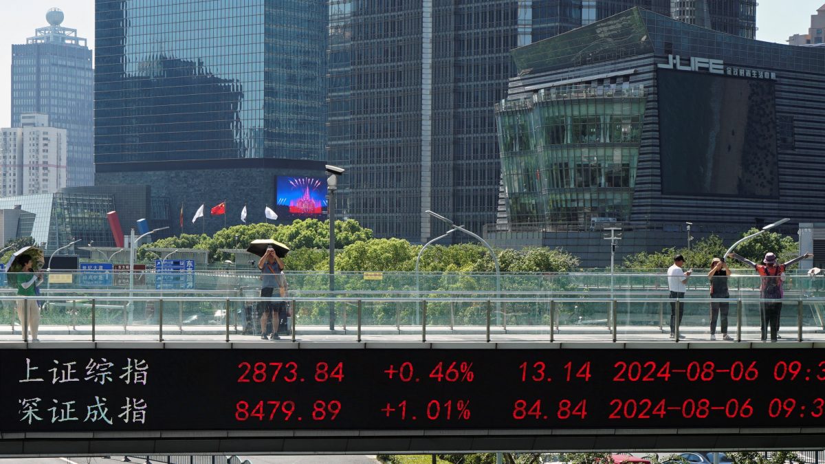 People take pictures on an overpass with a display of stock information in front of buildings in the Lujiazui financial district in Shanghai, China. File image/ Reuters People take pictures on an overpass with a display of stock information in front of buildings in the Lujiazui financial district in Shanghai, China. File image/ Reuters