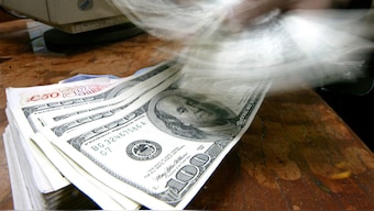 A money changer counts US dollars in Mumbai. Reuters