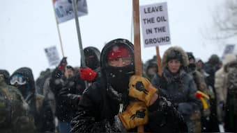 A Native American man leads a protest march with veterans and activists outside the Oceti Sakowin camp where "water protectors" continue to demonstrate against plans to pass the Dakota Access pipeline adjacent to the Standing Rock Indian Reservation, near Cannon Ball, North Dakota, US, December 5, 2016. Reuters