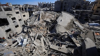 A Palestinian boy collects books at the site of an Israeli strike on a house, in Gaza City, on Monday. Reuters