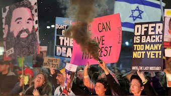 A demonstrator releases a black smoke flare as others gather during a protest calling for action to release the remaining hostages held captive in Gaza since the 2023 October 7 attacks by Palestinian militants, outside the Israeli Defence Ministry headquarters in Tel Aviv on March 1, 2025. Image- AFP