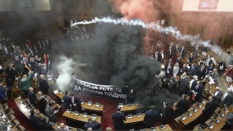 In this screen grab, taken from video provided by RTS Serbia, smoke bombs and flares are seen inside parliament, in Belgrade, Serbia on Tuesday. Image- AP