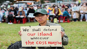 A man poses with his own placard at a "Stand up as Taiwan" rally in Taipei, Taiwan, on December 8, 2024. Reuters File
