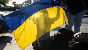 A Ukrainian boy seeking asylum in the U.S. plays with a Ukrainian flag after arriving at the PedWest border crossing at the San Ysidro Port of Entry in San Diego, California, U.S., April 13, 2022. REUTERS