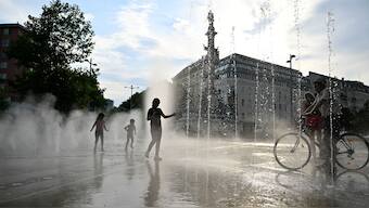People cool off under a water sprinkler during a heat wave in Vienna, Austria, August 14, 2024. Reuters file