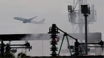 A plane takes off, as smoke rises from an area of an electrical substation a day after it caught fire and wiped out power at Heathrow International Airport, near London, Britain, March 22, 2025. Reuters