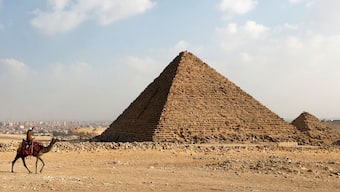 A camel guide waits for customers next to the pyramid of Khafre or 'Chefren' at the Giza pyramids plateau in Giza, Egypt December 18, 2020. File Photo/Reuters