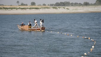 Fishermen on boat casting a net in the Indus River, in Hyderabad, Pakistan March 15, 2025. File Photo/Reuters