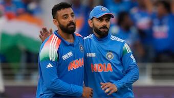 India leg-spinner Varun Chakravarthy celebrates with Virat Kohli after dismissing New Zealand opener Will Young in the Champions Trophy Group A match in Dubai on Sunday, 2 March. AP