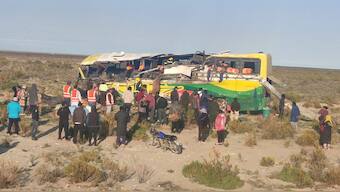 People stand near a damaged bus, after a fatal accident on the road to Uyuni, in Potosi, Bolivia. Reuters