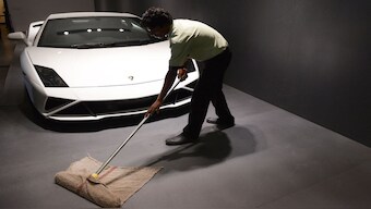 A Indian dealership worker mops the floor near a Lamborghini luxury model in New Delhi. Lamborghini sold 113 units in India, a 10 per cent increase over its previous best-ever performance of 2023. File image/AFP