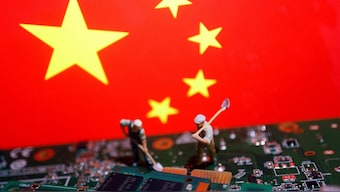 Worker miniatures are placed among the flag of China and printed circuit boards with semiconductor chips, in this illustration picture. File image/ Reuters