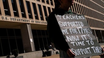 A protester stands near the US Department of Education headquarters after the agency said it would lay off nearly half its staff. File image/Reuters