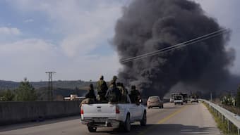 Smoke rises while members of the Syrian forces ride on a vehicle as they battle against a nascent insurgency by fighters from ousted leader Bashar al-Assad's Alawite sect, in Latakia, on 7 March. The atrocities against the minority sect has been on the rise. Reuters