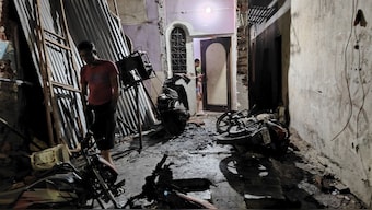 A man walks past damaged two-wheelers in front of a house in the aftermath of  violence that erupted on Monday, in Nagpur. Violence erupted in central Nagpur on Monday with stones hurled at police amid rumours that the Quran was burnt during an agitation by a right-wing body for the removal of Aurangzeb's tomb. PTI