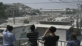 People take pictures of a construction site where a building collapsed in Bangkok on March 28, 2025, after an earthquake. A powerful earthquake rocked central Myanmar on March 28, buckling roads in capital Naypyidaw, damaging buildings and forcing people to flee into the streets in neighbouring Thailand. AFP