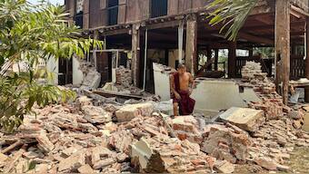 A Buddhist monk walks near a damaged building at a monastery compound after an earthquake in Naypyitaw, Myanmar. AP