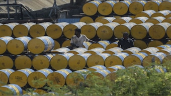 A worker stacks oil barrels in Chennai. Trump's tariff threat on Venezuelan oil could have an impact on India. Representational image/AFP