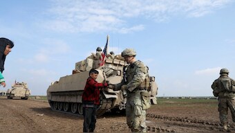 A soldier from the US-led coalition holds the hand of a boy during a joint U.S.- Kurdish-led Syrian Democratic Forces (SDF) patrol in the countryside of Qamishli in northeastern Syria. File image/ Reuters