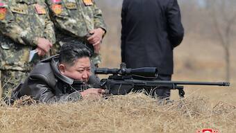 This picture taken on April 4, 2025 and released from North Korea's official Korean Central News Agency (KCNA) via KNS on April 5, 2025 shows North Korea's leader Kim Jong Un (C) looking through a rifle scope as he visits a training base of the Korean People's Army's special operations forces to observe a comprehensive training session, at an undisclosed location in North Korea. AFP