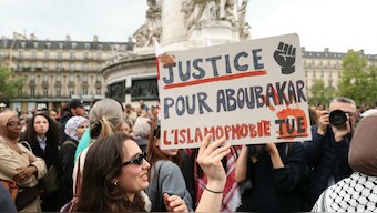 A protestor holds a sign reading "Justice for Aboubakar, Islamophobia kills" during a gathering in tribute to Aboubakar, the worshipper killed in a mosque at La Grand-Combe, and against Islamophobia, at the Place de la Republique in Paris. AFP