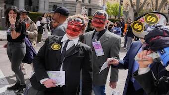 People depicting bankers march during the demonstration in Madrid. AP