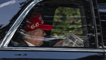President Donald Trump reads a The NY Post  as he arrives at Trump National Golf Club, Saturday, April 5, 2025, in Jupiter, Fla. AP