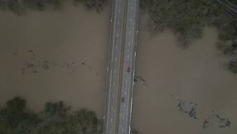 An aerial view of debris floating down the Kentucky River as vehicles drive over a bridge, in Frankfort, Ky. AP 