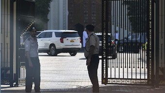 Omani security personnel watch a convoy believed to be carrying U.S. Mideast envoy Steve Witkoff in Muscat, Oman. AP