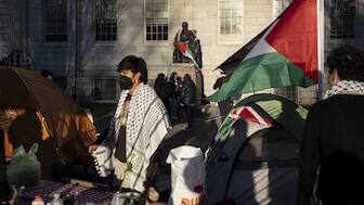 A student protester stands in front of the statue of John Harvard, the first major benefactor of Harvard College, draped in the Palestinian flag, at an encampment of students protesting against the war in Gaza, at Harvard University in Cambridge, Mass. File image/ AP