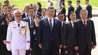 Chinese President Xi Jinping, center, walks with Vietnam's Communist Party General Secretary To Lam, right, as he lays a wreath at the Ho Chi Minh Mausoleum during his visit to Hanoi, Vietnam. AP