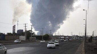 In this photo provided by Islamic Republic News Agency, IRNA, a black smoke rises in the sky as vehicles drive on the road after a massive explosion near the southern port city of Bandar Abbas, Iran. AP