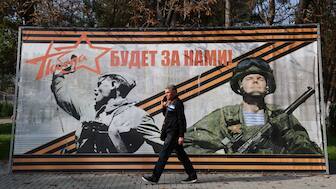 A man walks past a banner reading "Victory will be ours!" in the settlement of Sovetsky, Crimea, October 30, 2024. File Image/Reuters