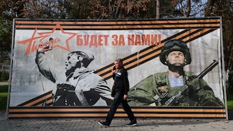 A man walks past a banner reading "Victory will be ours!" in the settlement of Sovetsky, Crimea, October 30, 2024. File Image/Reuters