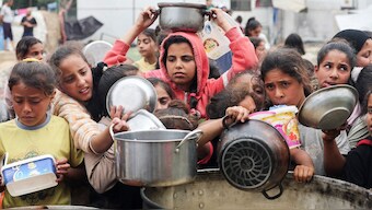 Palestinians wait to receive food cooked by a charity kitchen, in Nuseirat, central Gaza Strip, April 8, 2025. (Photo: Reuters)