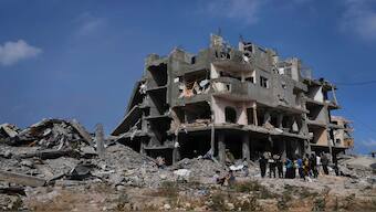 Palestinians look at the damage after an Israeli army airstrike in Beit Lahia, northern Gaza Strip, on Monday. AP 