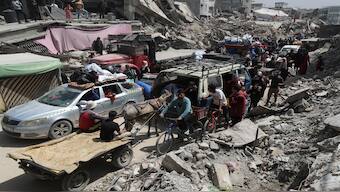 Palestinians make their way with belongings as they flee their homes, after the Israeli army issued evacuation orders, in the Shujaiya neighborhood of Gaza City, on Thursday. Reuters