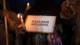 A demonstrator holds a placard with a message and a candle during a candlelight vigil to condemn the Pahalgam terror attack, in Srinagar, on April 23, 2025. REUTERS/Adnan Abidi/File Photo 