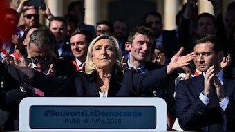 RN party's President Jordan Bardella (R) applauds as President of Rassemblement National parliamentary group Marine Le Pen gestures after delivering a speech during a rally in her support, after she was convicted of a fake jobs scheme at the EU parliament, in Paris on April 6, 2025. Image- AFP