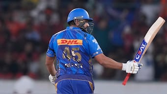 Mumbai Indians opener and former captain Rohit Sharma raises his bat in celebration after completing his half-century against Sunrisers Hyderabad at Hyderabad's Rajiv Gandhi International Stadium. AP