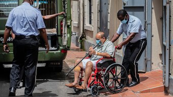 Businessman Mehul Choksi is taken to a police van via a wheelchair by a police officer after attending a court hearing, in Roseau, Dominica, June 10, 2021. File Photo/AP