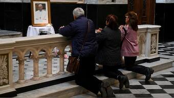 People pray next to a picture of Pope Francis at the Basilica of San Jose de Flores, after his death was announced by the Vatican, in Buenos Aires, Argentina, April 21, 2025. Reuters