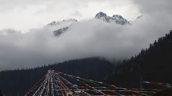 Peak of the Konpo Lhastan mountain and Tibetan prayer flags are pictured at Gaoshang Pasture Scenic Area, during a government-organized tour, in Lulangzhen, Tibet Autonomous Region, China, March 31, 2025. Reuters
