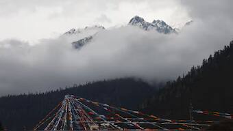 Peak of the Konpo Lhastan mountain and Tibetan prayer flags are pictured at Gaoshang Pasture Scenic Area, during a government-organized tour, in Lulangzhen, Tibet Autonomous Region, China, March 31, 2025. Reuters